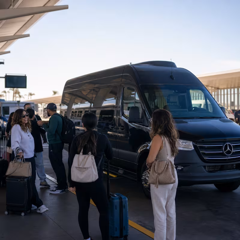 Group boarding a white charter bus for Airport Transportation transportation in Goodyear