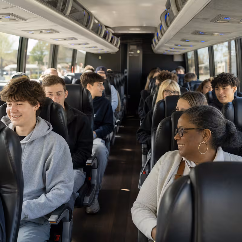 Group boarding a white charter bus for School Transportation transportation in Goodyear