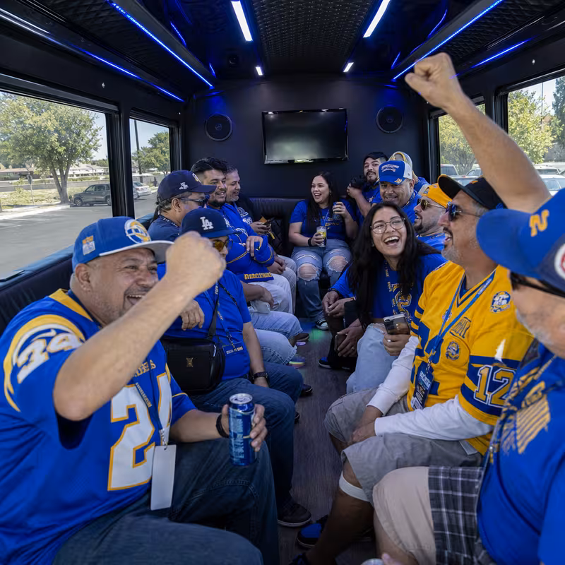 Group boarding a white charter bus for Sporting Event Transportation transportation in Goodyear
